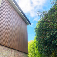 Spiced oak slatted cladding installation in Caterham