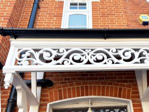 Detail of finials of white double door canopy installation